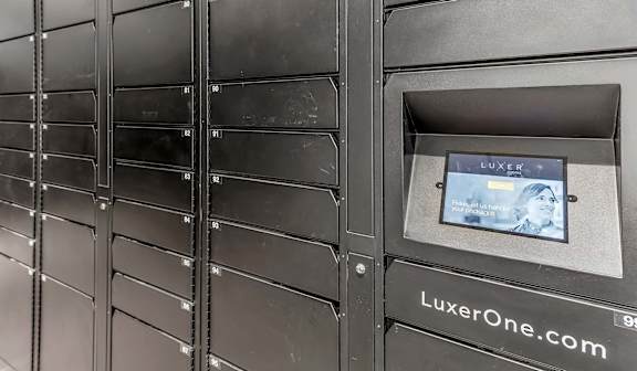 A row of black mailboxes with a digital display showing a website.