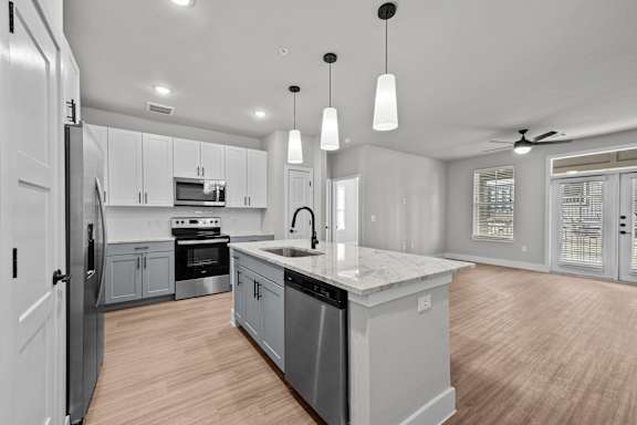 A modern kitchen with a central island and stainless steel appliances.