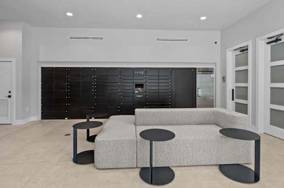 A modern living room with a grey sofa and black coffee table.