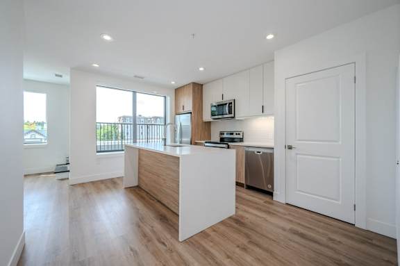 an open kitchen with a large island and a white door
