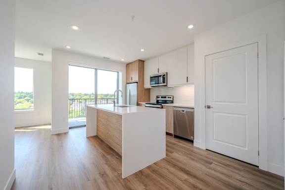 a white kitchen with a large island and a window