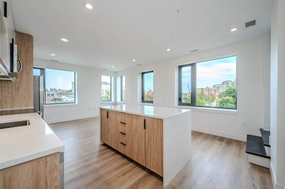 an open kitchen and living room with a view of the city