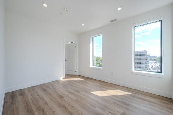 an empty living room with white walls and wood floors