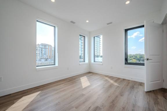 a living room with a hard wood floor and three windows