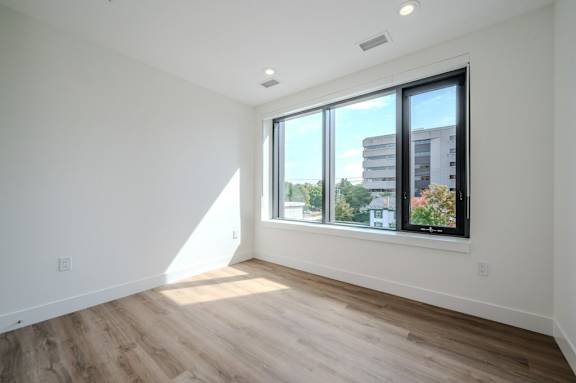 a living room with a large window and wooden floors