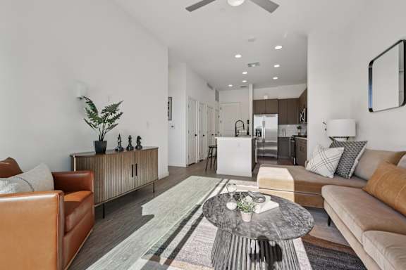 A modern living room with a brown leather chair and a grey coffee table. at Lura Vegas Apartments, Las Vegas