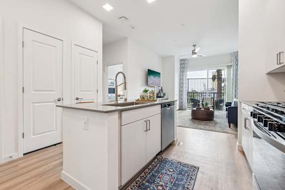 A kitchen with white cabinets and a wooden floor.at Coya Apartments, Las Vegas, NV, 89102