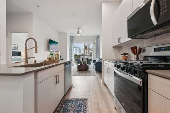 A modern kitchen with a black stove top oven.at Coya Apartments, Las Vegas
