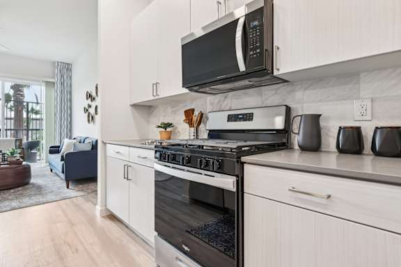 A modern kitchen with a stove top oven and microwave above it.at Coya Apartments, Nevada