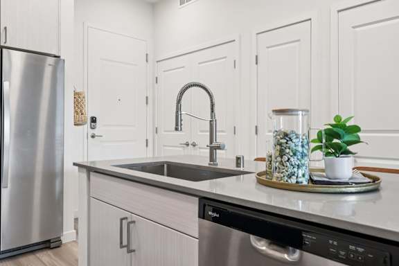 A modern kitchen with a stainless steel refrigerator and a black dishwasher.at Coya Apartments, Nevada, 891