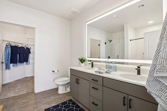 A bathroom with a white toilet, a sink, and a mirror. at Lura Vegas Apartments, Nevada, 89103