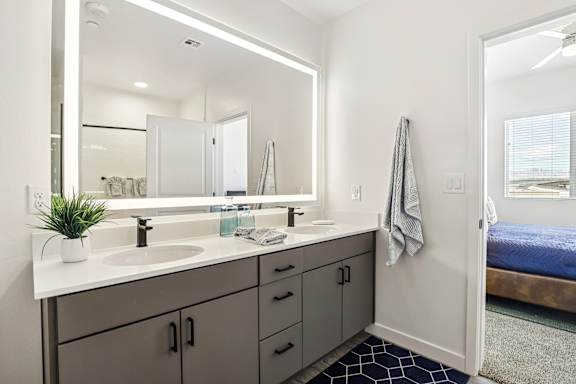 A bathroom with a white sink and a mirror above it. at Lura Vegas Apartments, Nevada