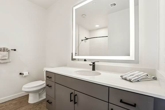 A bathroom with a white counter top and a white toilet. at Lura Vegas Apartments, Nevada, 89103