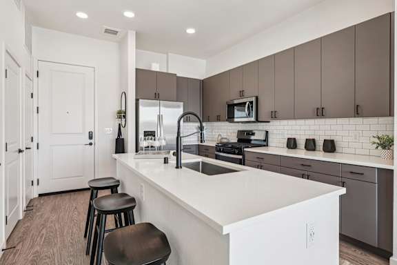 A modern kitchen with a white countertop and brown cabinets. at Lura Vegas Apartments, Nevada, 89103