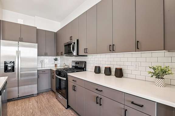 A kitchen with a white counter top and grey cabinets. at Lura Vegas Apartments, Las Vegas, 89103