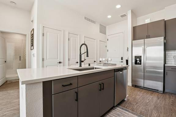 A modern kitchen with a white countertop and dark brown cabinets. at Lura Vegas Apartments, Nevada, 89103