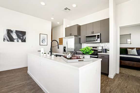 A modern kitchen with a white island and stainless steel appliances. at Lura Vegas Apartments, Las Vegas, NV