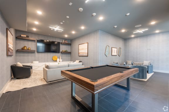 a game room with a pool table and couches at Aura Vegas Apartments, Nevada