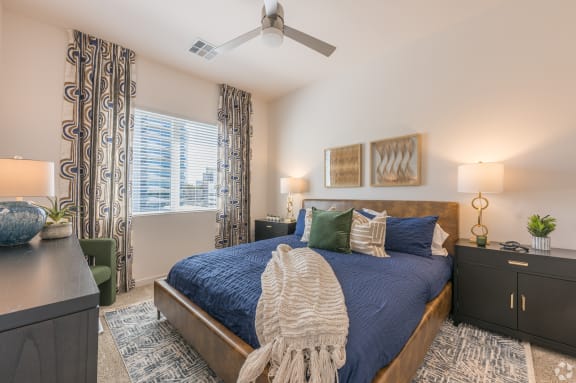 a bedroom with a large bed and a ceiling fan at Aura Vegas Apartments, Nevada