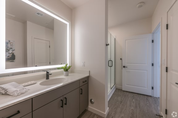 a bathroom with a large mirror and a sink and a shower at Aura Vegas Apartments, Las Vegas, NV 89103