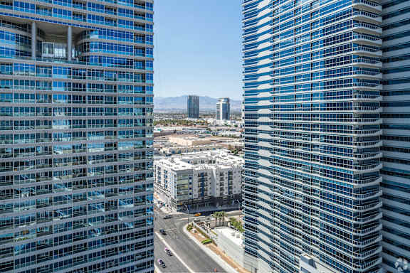 Two tall buildings with blue glass windows stand next to each other.