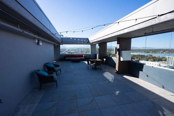 A patio with a table and chairs overlooking a body of water at Denver Metro Village Apartments, Colorado, 80204