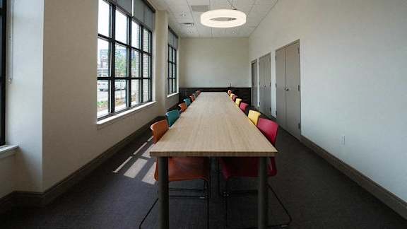 A conference room with a long table and chairs at Denver Metro Village Apartments, Colorado