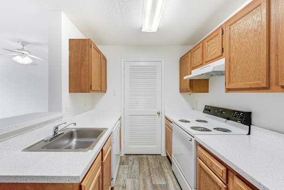 A kitchen with wooden cabinets and a white countertop at Acclaim at Sterling, Sterling, Virginia