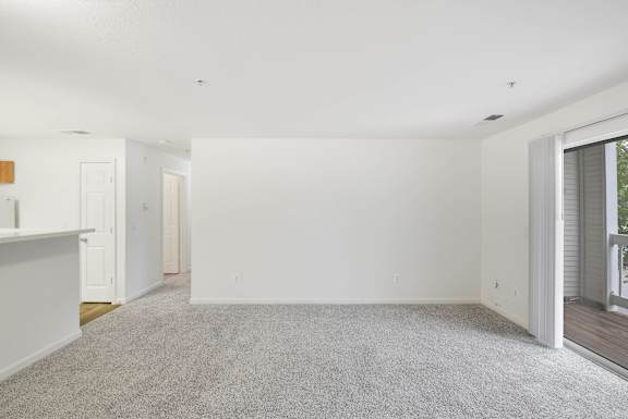 Spacious living room with carpet and balcony access at Acclaim at Ashburn Apartments, Ashburn, 20147