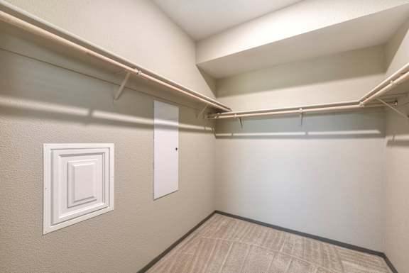 Walk-in closet with hanging rods and shelving at Anton Arcade Apartments, California