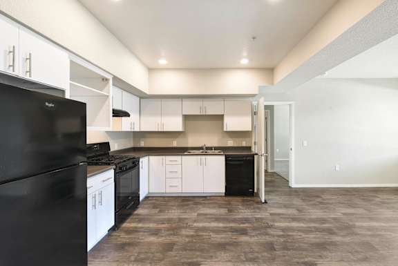 Modern kitchen with white cabinets and black appliances at Anton Arcade Apartments, Sacramento, CA