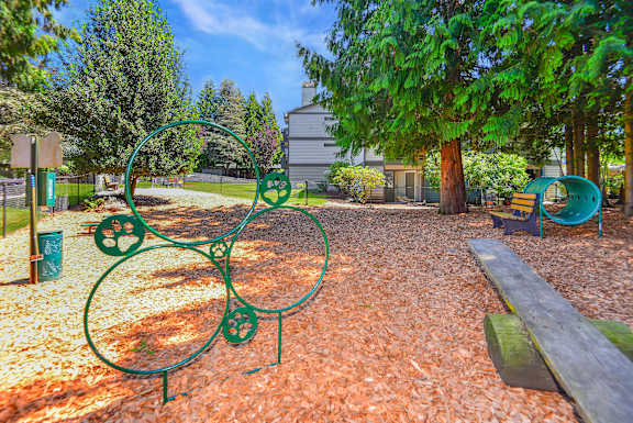 A playground with a green metal structure and a bench.