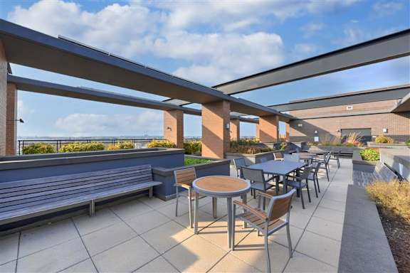 A patio with tables and chairs under a roof.