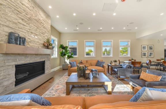 A living room with a stone fireplace and a variety of seating options.