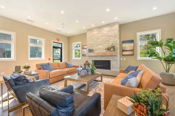 A living room with a stone fireplace and a large couch.