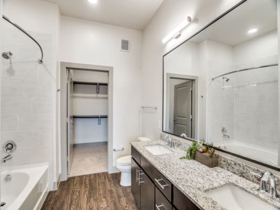 a bathroom with a large mirror and a shower and a sink
