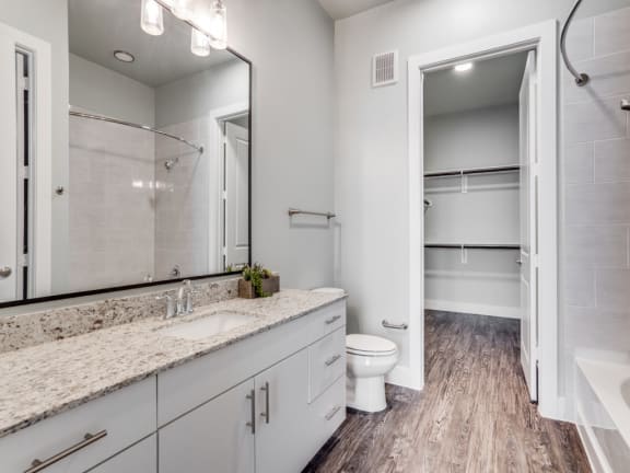 a white bathroom with a large mirror and a toilet