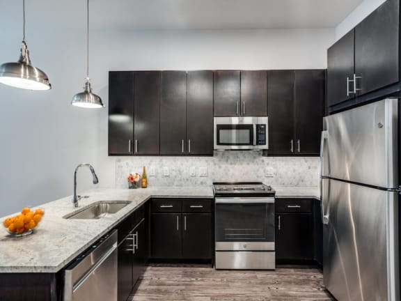a kitchen with stainless steel appliances and marble counter tops