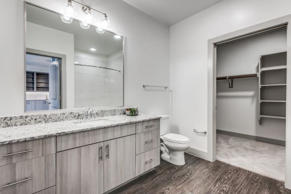 a white bathroom with a large mirror and a white toilet