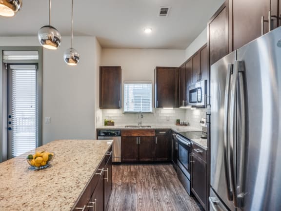 a kitchen with stainless steel appliances and a marble counter top