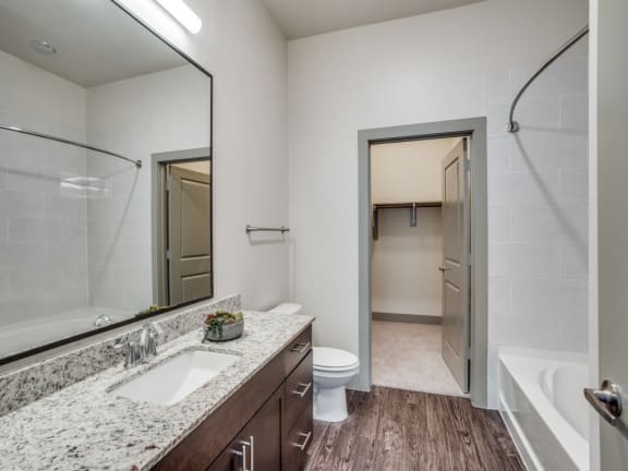a bathroom with a large mirror and a toilet and a sink