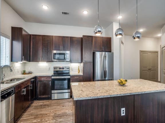 a kitchen with stainless steel appliances and a marble counter top
