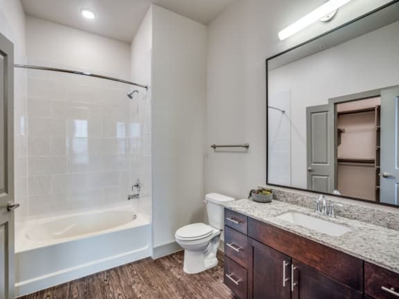 a bathroom with a shower toilet and sink and a mirror