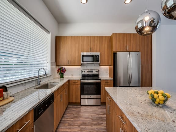 a kitchen with wooden cabinets and granite counter tops and stainless steel appliances