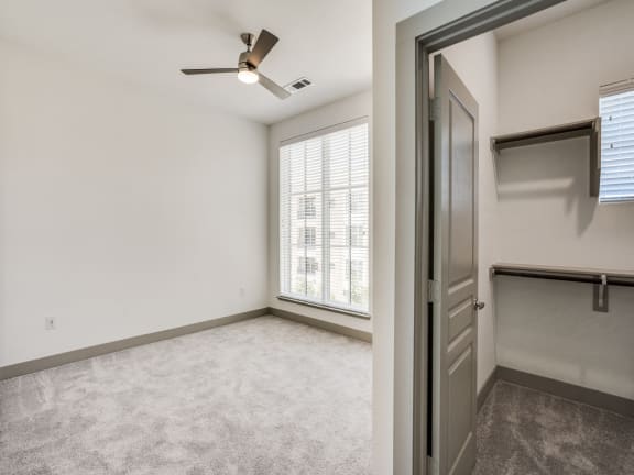 an empty living room with a closet and a window