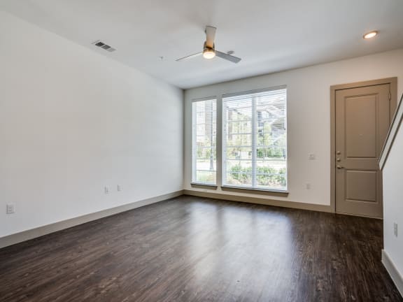 an empty living room with white walls and a large window