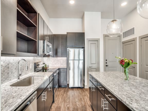 a kitchen with marble counter tops and stainless steel appliances