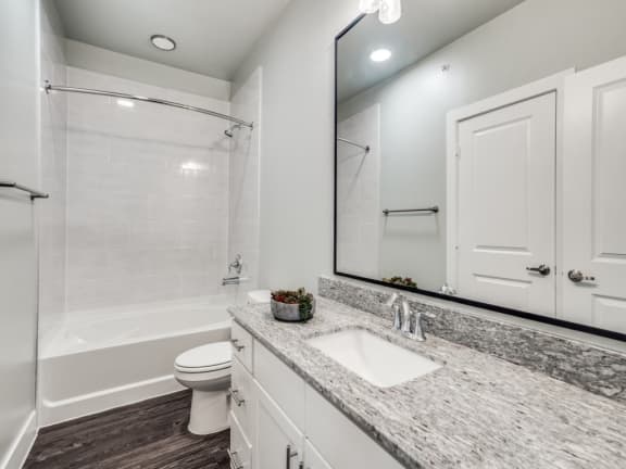 a white bathroom with a large mirror and a sink