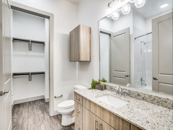 a bathroom with white walls and wood flooring
