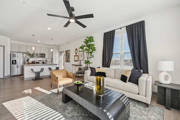 A modern living room with a black coffee table and a white sofa.